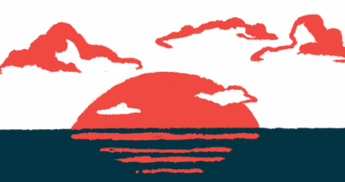 The sun is seen setting over water.