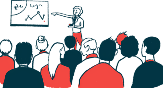 A conference speaker points to a chart while an audience listens.
