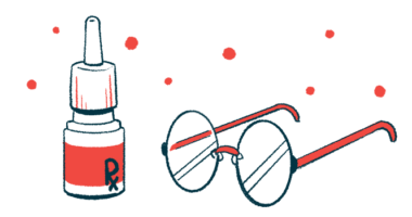 A bottle of prescription eyedrops sits next to a pair of eyeglasses.