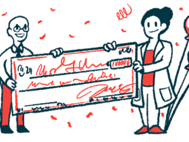 Two people, flanked. by balloons, hold an oversized check.