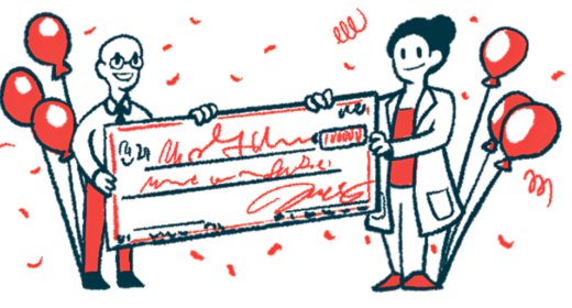 Two people, flanked. by balloons, hold an oversized check.