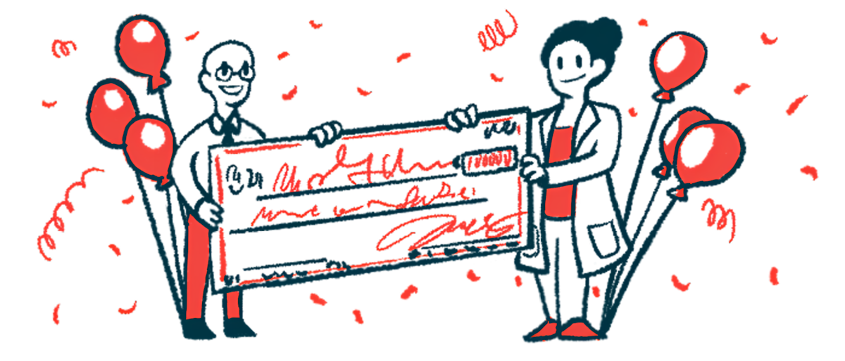 Two people, flanked. by balloons, hold an oversized check.